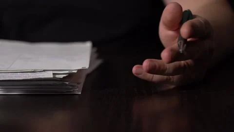 Close-up of Hands with Pen on Paper Documents Sitting Stock Footage 167885749