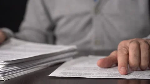 Close-up of Hands with Pen on Paper Documents Sitting Stock Footage 167885842