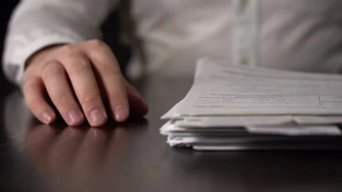 Close-up of Hands with Pen on Paper Documents Sitting Stock Footage 167885974