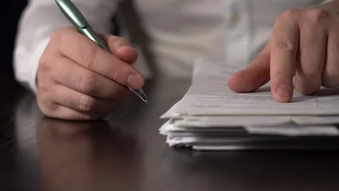 Close-up of Hands with Pen on Paper Documents Sitting Stock Footage 167886092