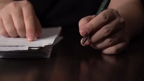 Close-up of Hands with Pen on Paper Documents Sitting Stock Footage 167886999