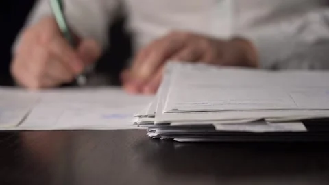 Close-up of Hands with Pen on Paper Documents Sitting Stock Footage 167887094