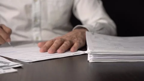 Close-up of Hands with Pen on Paper Documents Sitting Stock Footage 167887203