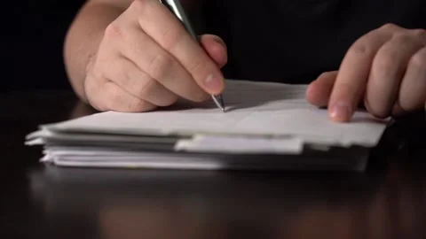 Close-up of Hands with Pen on Paper Documents Sitting Stock Footage 167887254