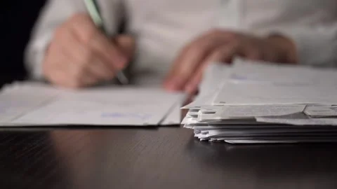 Close-up of Hands with Pen on Paper Documents Sitting Stock Footage 167887487