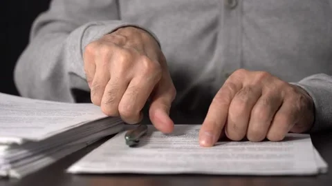 Close-up of Hands with Pen on Paper Documents Sitting Stock Footage 167887543