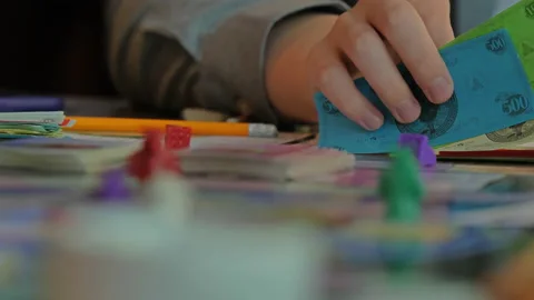 Close-up of the hands of people playing the game Monopoly. Stock Footage 140971184