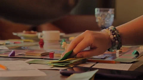 Close-up of the hands of people playing the game Monopoly. Stock Footage 140971497
