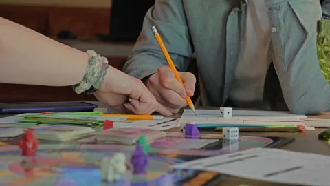 Close-up of the hands of people playing the game Monopoly. Stock Footage 140972796