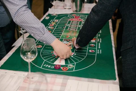 Close-up, hands of people playing in a wine casino, a man's hand with game chips Stock Photos