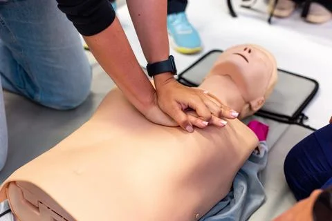 Close-up of hands performing CPR on a training manikin during a first aid class. Foto stock