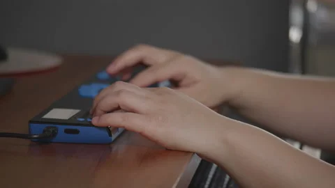 Close-up hands of person with blindness disability using braille display Stock Footage 194505178