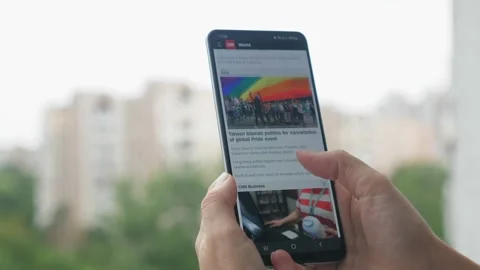 Close-up hands with a phone and watching the latest news. A woman monitors the Video stock 204853045
