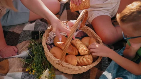Close Up of Hands Picking Baked Snacks from Picnic Basket on Checkered Blanket Stock Footage 305012639