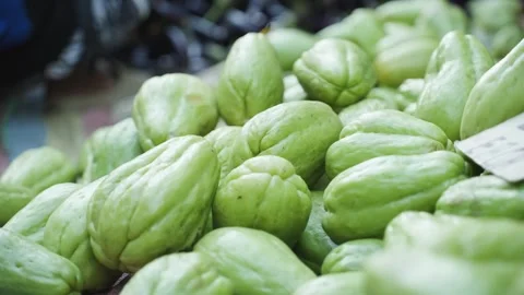 Close-Up Hands Placing and Organizing Fresh Chayote at Local Market Stock Footage 341646105