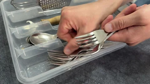 Close up hands placing forks and spoons into plastic drawer organizer in Stock Footage 336978843