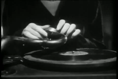 Close-up of hands placing needle on record, 1940s Stock-Footage 11353155