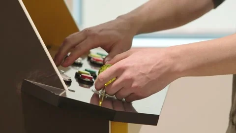 Close up of hands playing on an 80’s arcade machine Stock Footage 251468245
