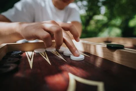 Close-up of hands playing backgammon outdoors on a sunny day Stock Photos