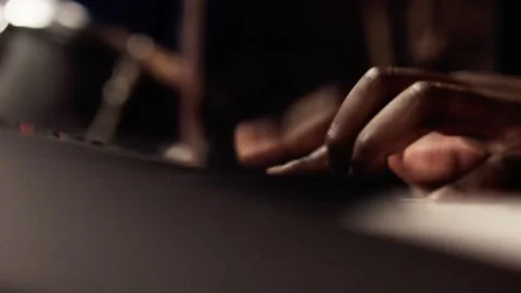 Close-up of hands playing fast keyboard passage, drummer visible in background Stock Footage 345590927