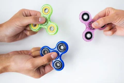 Close up of hands playing with fidget spinners Stock Photos