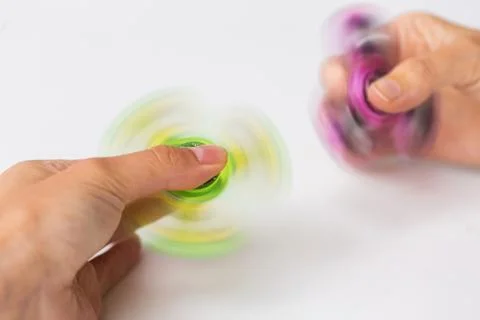 Close up of hands playing with fidget spinners Stock Photos