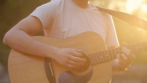 Close up of hands playing the guitar in the beautiful sunset slow motion Stock Footage 76010003