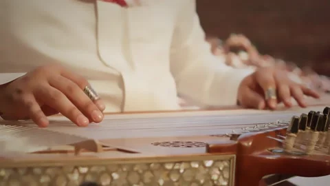 Close-up of hands playing a traditional Middle Eastern qanun, a stringed Vidéo 333615611