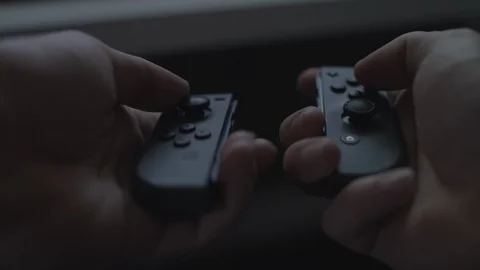 Close up of hands playing with/using dual black video game controllers. 4k UHD. Stock Footage 90211409