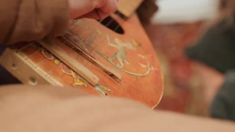 Close-up hands playing worn acoustic guitar, plucking strings and changing Stock Footage 345672273