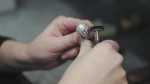 Close up hands polishing large ring with white opal stone in the middle Stock Footage 130670610