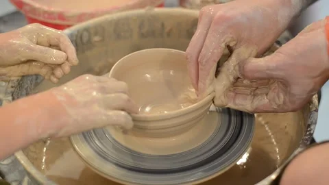 Close up hands of the potter and his student Stock Footage 130477339