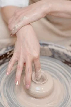 Close up hands of a potter makes ceramic pottery from clay on a pottery wheel Stock Photos
