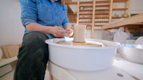 Close up of hands in pottery studio creating mug on pottery wheel Stock Footage 221949730
