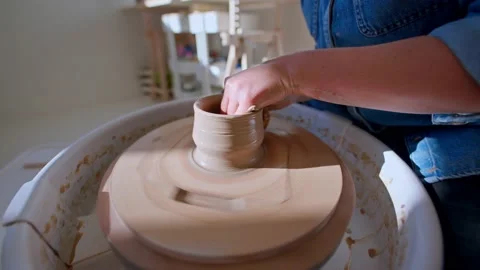 Close up of hands in pottery studio shaping clay mug on pottery wheel 库存影片 221949723