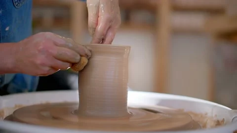 Close up of hands in pottery studio shaping mug on pottery wheel 库存影片 221949823