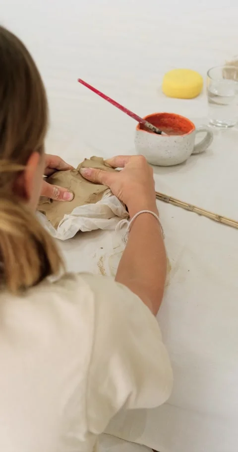 A close-up of the hands of a pottery teacher who is explaining to a teenage girl Stock Footage 289167341