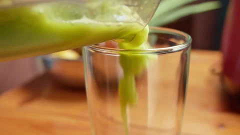 Close-up of hands pouring green leaf salad Kale smoothie into a glass. Vídeos de archivo 157408852