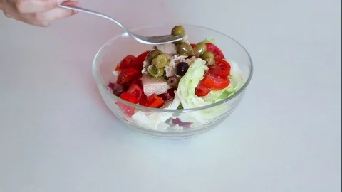 Close up of hands pouring some olives into a salad Stock Footage 111586353