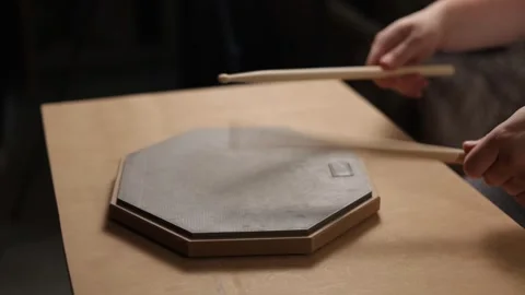 Close-up of hands practicing drumming on a practice pad with sticks Video stock 341737453