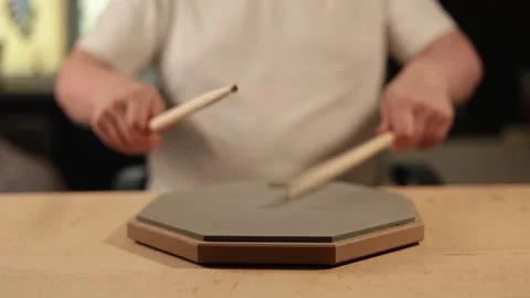 Close-up of hands practicing drumming on a practice pad with drumsticks Vidéo 341737468