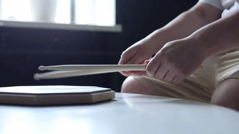 Close-up of hands practicing drumming on a practice pad with sticks Stockbeeldmateriaal 341969025