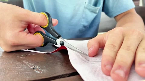 Close-Up of Hands Precision Trimming Fabric Edge With Small Scissors Stock Footage 346499366