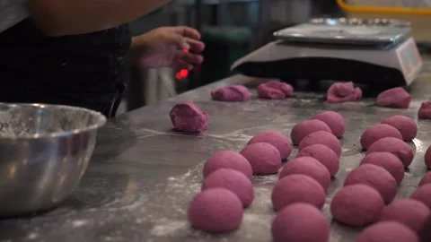 Close up of hands preparing pink dough for buns in bakery Stock Footage 146836416