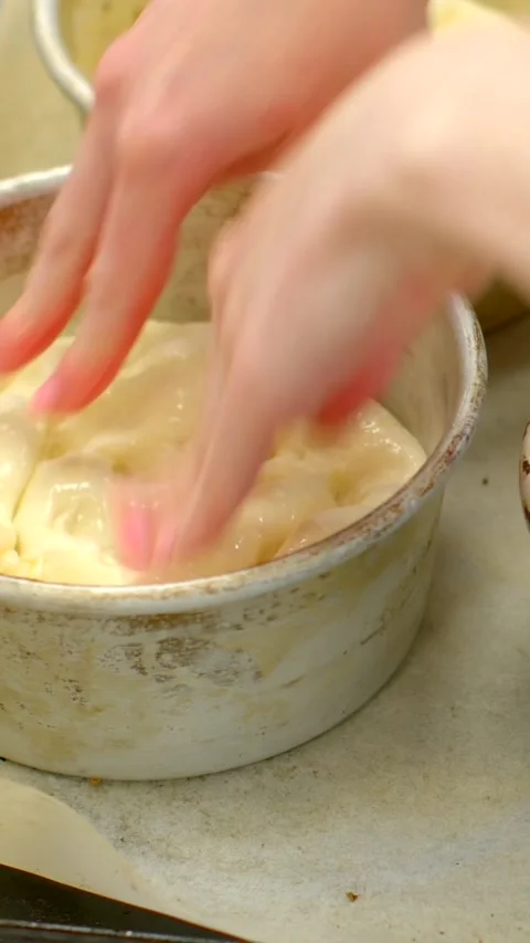 Close-up hands pressing dough into round metal baking molds in artisanal bakery Видео 344571020