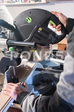 Close up of hands by profession a carpenter cuts wooden boards with a circular Stock Photos