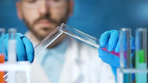 Close-up hands of professional chemist pouring liquid reactive using beaker in Stockbeeldmateriaal 101396132