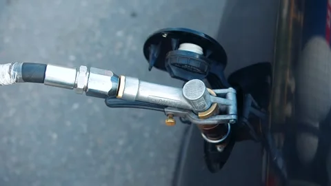 Close up of hands in protective gloves that disconnect the gas nozzle from valve Stock Footage 312964013