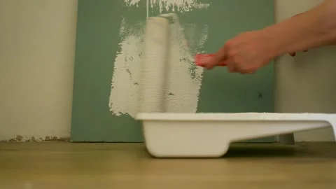 Close up of hands in protective work gloves painting wall with white colour Video stock 139716693