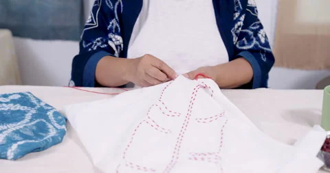 Close up hands pull needle through cotton cloth, forming resist stitching lines Stock Footage 328488467